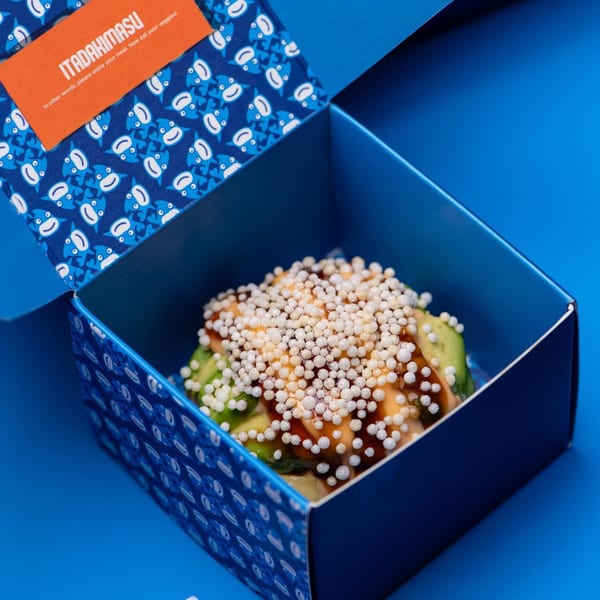 Sweetfish Poké Bowls & Sushi's poke bowl with avocado and crispy toppings in a blue box.